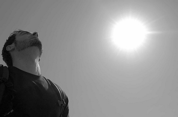 man looking up with sun