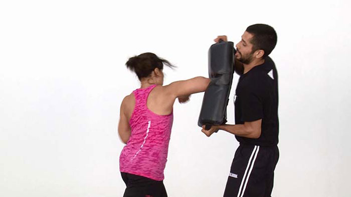 woman punching a bag in a self-defense class